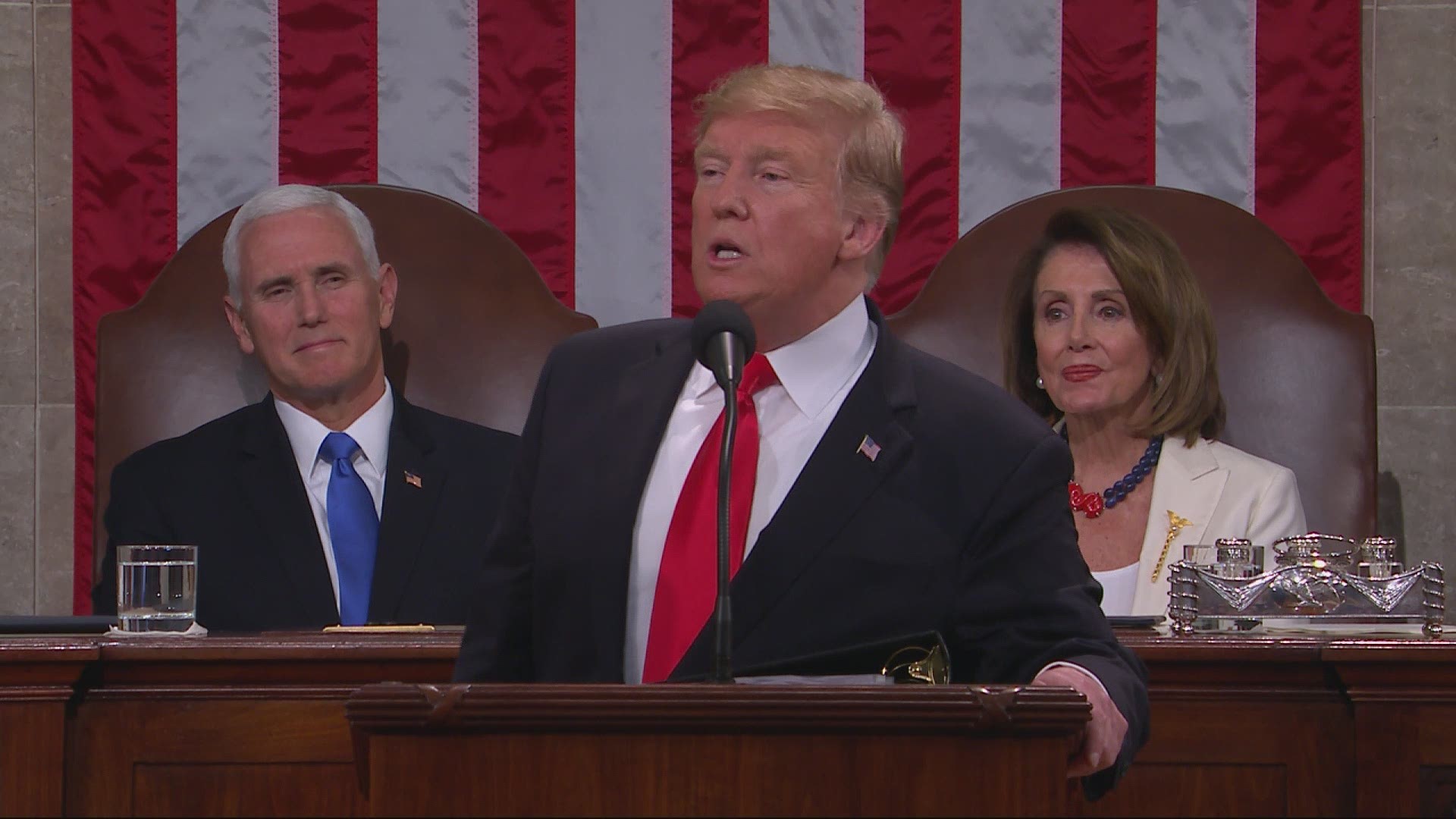 Trump, whose red tie was oddly askew, declared 'our country is vibrant and our economy is thriving like never before.'
