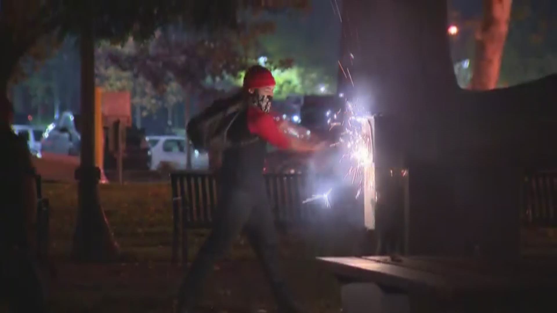 Protester hammers power source with bat