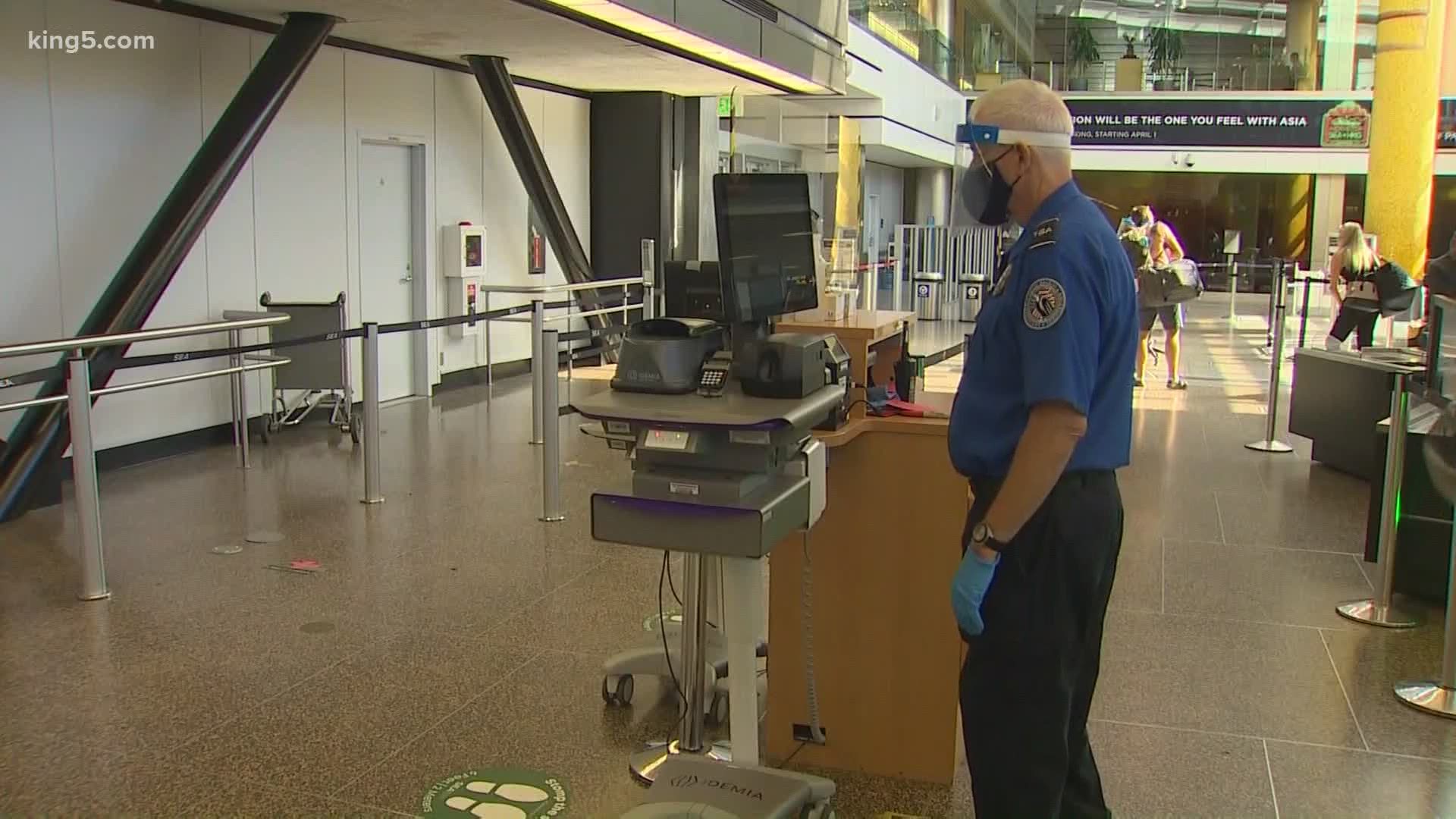Sea-Tac Airport’s new COVID-19 safety protocols include signs encouraging social distancing, ID scanners at TSA checkpoints and no scanning bins for empty items.