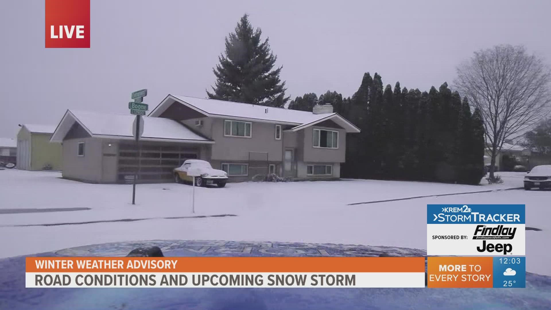 Drivers face some slick road conditions as snow falls in the Spokane area on Monday.