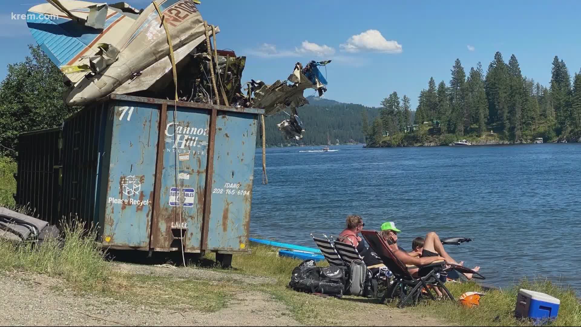 Viewer photos shared with KREM showed part of the wreckage being stored in dumpsters out in the open and people swimming in the lake just feet away.