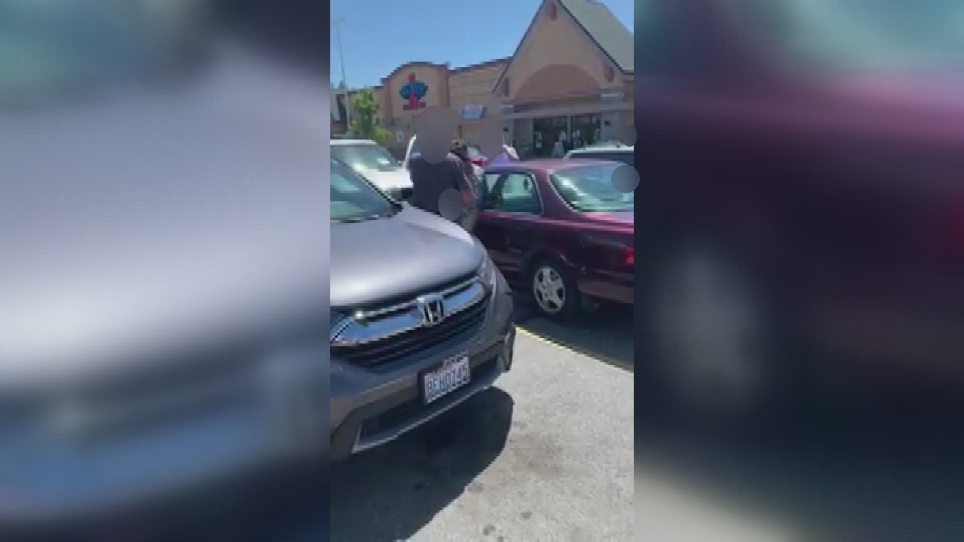 WARNING: This video contains profanity. It shows two people in a parking lot on Spokane's South Hill who are apparently holding a woman at gunpoint.