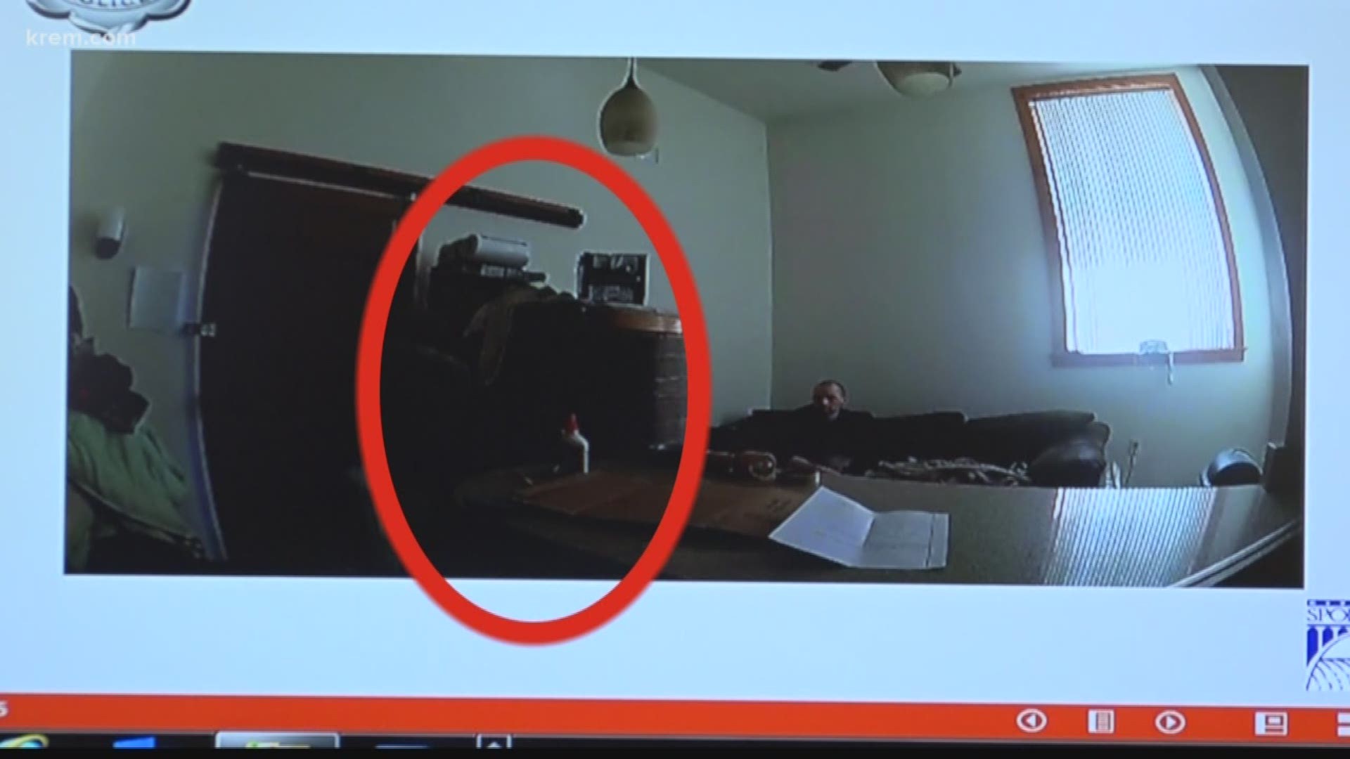 Video shows Ronald Acre sitting on a couch in the back of his apartment. If front of him is another couch that's been propped up.