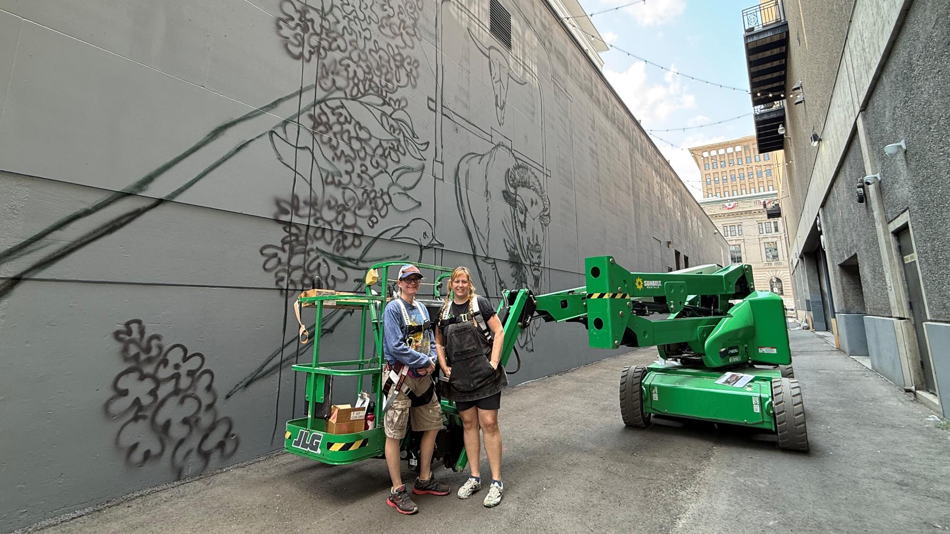 Artists painting one of downtown Spokane's largest murals near River Park Square