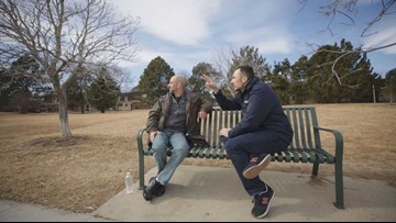 Christopher Zadnik sits with 9NEWS Investigator Jeremy Jojola on a bench as he talks about his various thoughts on the trails left by planes in the sky. (Photo: 9NEWS)